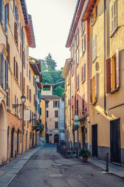Brescia, İtalya, 11 Eylül 2019: Pencereleri kepenkli, sokak lambaları, restoran masaları, tarihi merkez, dikey manzara, Lombardy