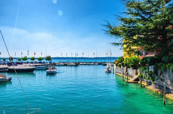 Puerto de lago de Garda con agua azul turquesa, muelle de madera y yate —  Fotos de Stock