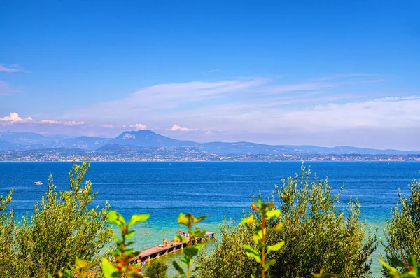 Lago de Garda con agua azul turquesa y muelle de madera —  Fotos de Stock