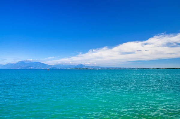 Lago de Garda azul turquesa superficie de agua con vista a la cordillera del Monte Baldo —  Fotos de Stock