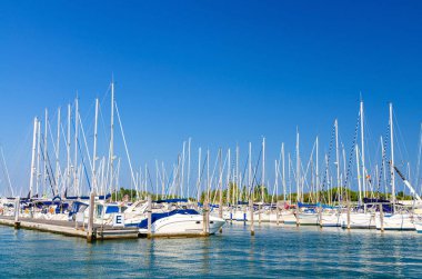 Beyaz yatlar, Sottomarina limanındaki liman limanında rıhtıma demirlemiş durumda.