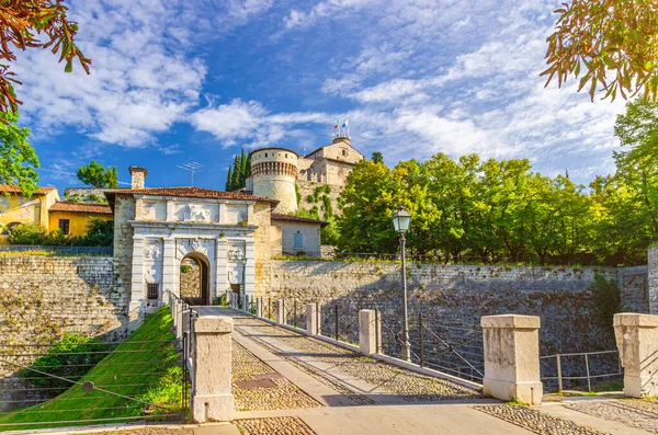 Castello ya da Brescia Kalesi ya da Cidneo Tepesi 'ndeki İtalya Şahini hendeği üzerinde tarihi şehir merkezinde yeşil parkı, mavi bulutlu gökyüzü arka planı, Lombardy, Kuzey İtalya