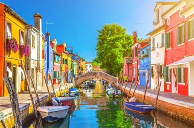 Burano adasının renkli evleri. İtalya 'nın Venedik Bölgesi' nde, Venedik Eyaleti 'nde balıkçı tekneleri ve taş köprüsü olan dar su kanalının fondamenta dolgusu üzerinde çok renkli binalar. Burano kartpostalı