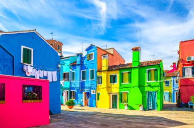 Burano adasının renkli evleri. Küçük kasaba meydanında çok renkli binalar güneşli yaz gününde mavi gökyüzü arka planı Venedik Bölgesi, Kuzey İtalya. Burano kartpostalı