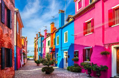 Burano adası, renkli binalar arasında dar kaldırım taşı caddesi çok renkli duvarlar, mavi gökyüzü güneşli yaz günü, Venedik Eyaleti, Veneto Bölgesi, Kuzey İtalya. Burano kartpostalı