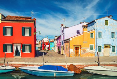 Burano adasının renkli evleri. Venedik Bölgesi, Veneto Bölgesi, Kuzey İtalya 'da balıkçı tekneleriyle dolu dar su kanalının fondamenta dolgusu üzerinde çok renkli binalar. Burano kartpostalı