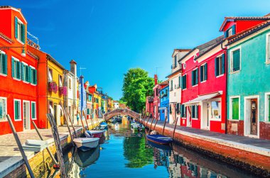Burano adasının renkli evleri. İtalya 'nın Venedik Bölgesi' nde, Venedik Eyaleti 'nde balıkçı tekneleri ve taş köprüsü olan dar su kanalının fondamenta dolgusu üzerinde çok renkli binalar. Burano kartpostalı