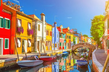 Burano adasının renkli evleri. İtalya 'nın Venedik Bölgesi' nde, Venedik Eyaleti 'nde balıkçı tekneleri ve taş köprüsü olan dar su kanalının fondamenta dolgusu üzerinde çok renkli binalar. Burano kartpostalı