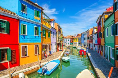 Burano adasının renkli evleri. Güneşli bir günde Venedik Bölgesi, Veneto Bölgesi, Kuzey İtalya 'da balıkçı teknelerinin bulunduğu dar su kanalının fondamenta dolgusu üzerinde çok renkli binalar. Burano kartpostalı