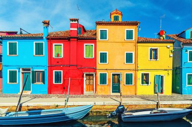Burano adasının renkli evleri. Venedik Bölgesi, Veneto Bölgesi, Kuzey İtalya 'da balıkçı tekneleriyle dolu dar su kanalının fondamenta dolgusu üzerinde çok renkli binalar. Burano kartpostalı