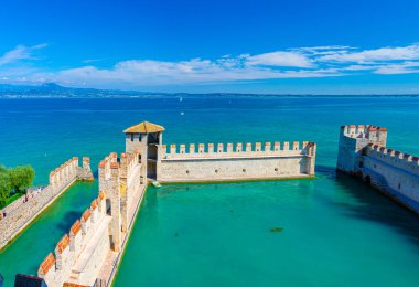 Sirmione, İtalya, 11 Eylül 2019: Turkuaz suyla güçlendirilmiş küçük liman, Scaligero Kalesi Castello Kalesi, Garda Gölü kasabası, taş kuleleri ve tuğla duvarları olan ortaçağ kalesi, Lombardiya Kalesi
