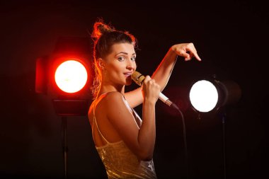 Bir kadın stüdyoda bir şarkı söyler