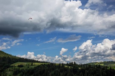 Dağların üzerinden yaz gündüz uçan yamaçparaşütü