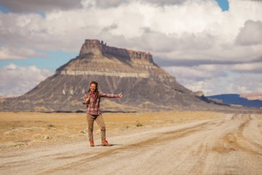 ABD'de bir yolda yürüyen otostopçu kadın