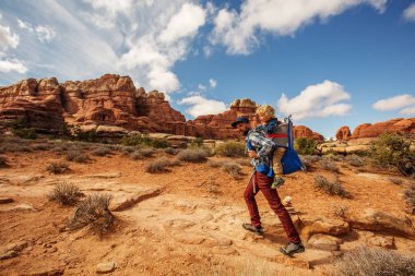 Uzun yürüyüşe çıkan kimse çocuk Canyonlands Milli Parkı'nda, gökyüzünde iğneler ile,