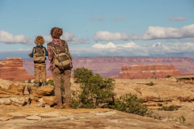 Uzun yürüyüşe çıkan kimse çocuk Canyonlands Milli Parkı'nda, gökyüzünde iğneler ile,