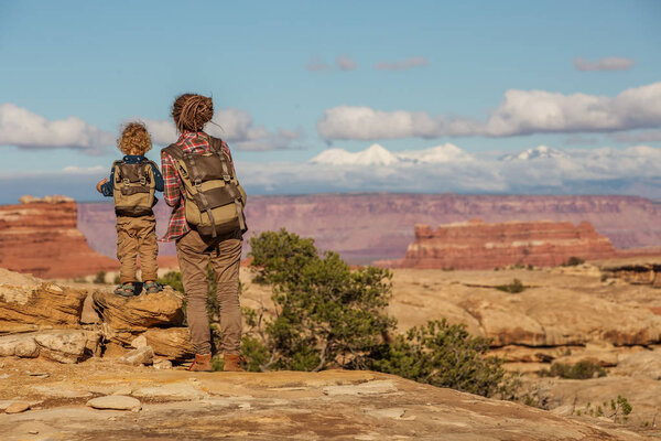 Hiker with boy in Canyonlands National park, needles in the sky,