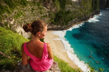  bir uçurumun kenarında oturan ve gün batımına bakan kadın, Nus