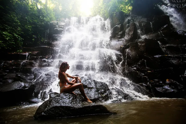 Kvinna praxis yoga nära vattenfall i Bali, Indonesien — Stockfoto