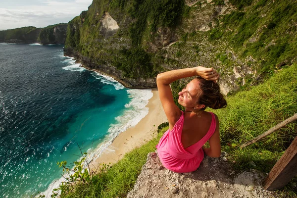 Wanita duduk di tepi tebing dan melihat matahari terbenam, Nus — Stok Foto