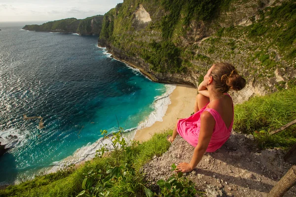 Mujer sentada en el borde de un acantilado y mirando el atardecer, Nus — Foto de Stock