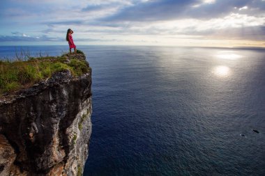  bir uçurumun kenarında oturan ve gün batımına bakan kadın, Nus