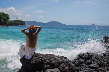 Tropik plaj tatilinde beyaz elbiseli mutlu kadın