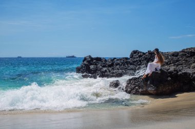 Tropik plaj tatilinde beyaz elbiseli mutlu kadın