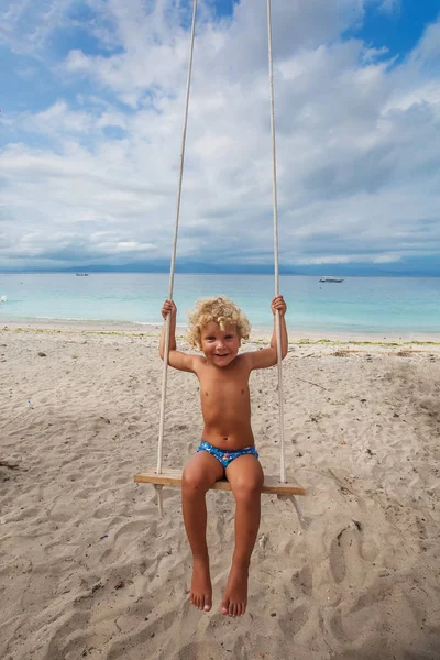 Tył chłopców huśtawki grają na plaży — Zdjęcie stockowe