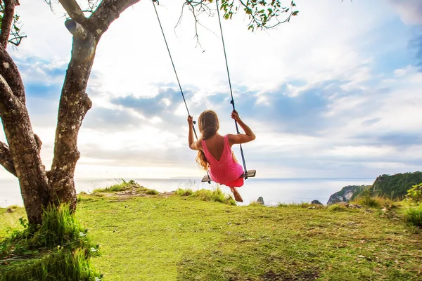 Vrouw swingend op een schommel op een tropisch eiland — Stockfoto