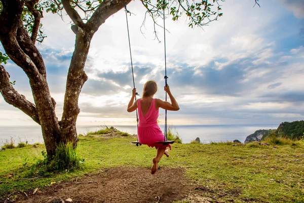 Kvinna svänger på en gunga på en tropisk ö — Stockfoto