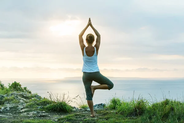 Mujer caucásica practicando yoga en la orilla del mar — Foto de Stock