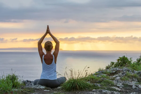 Mujer caucásica practicando yoga en la orilla del mar — Foto de Stock