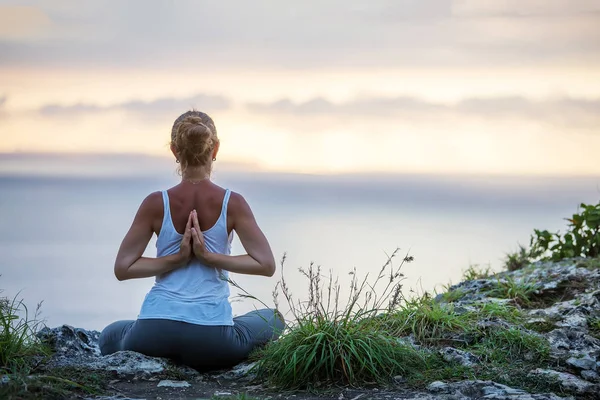 Kaukasische Frau praktiziert Yoga an der Küste — Stockfoto