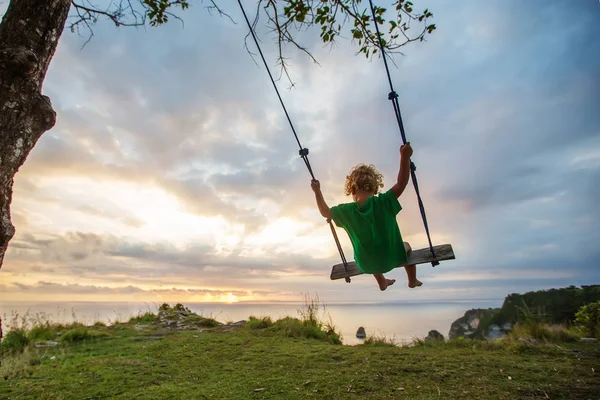 Il retro dei ragazzi Swings stanno giocando sulla spiaggia — Foto Stock