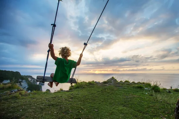 Il retro dei ragazzi Swings stanno giocando sulla spiaggia — Foto Stock