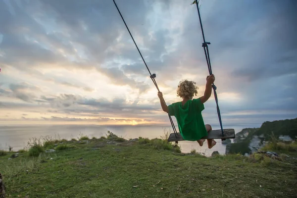 Bak på pojkarna gungor spelar på stranden — Stockfoto