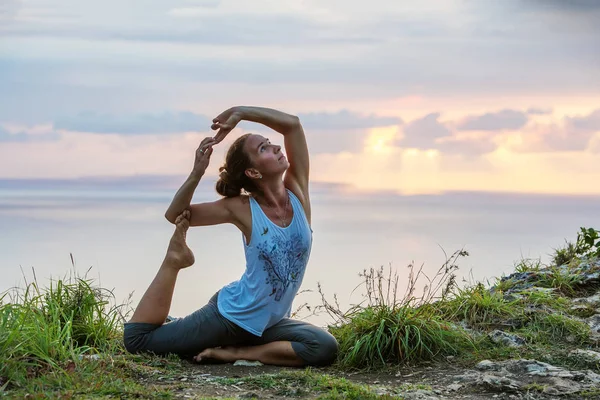 Kaukasisk kvinna utövar yoga på stranden — Stockfoto