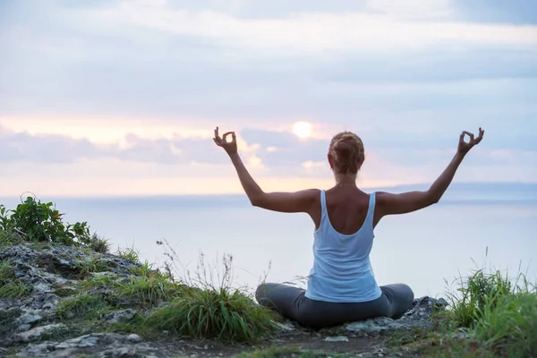 Kaukasische Frau praktiziert Yoga an der Küste — Stockfoto