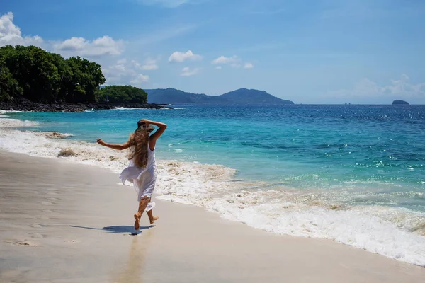 Щаслива жінка в білій сукні на тропічному пляжі — стокове фото