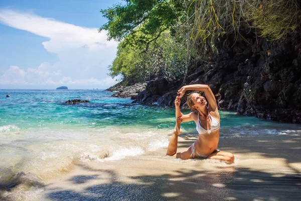 Mujer caucásica practicando yoga en la orilla del mar — Foto de Stock