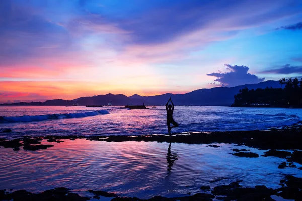 Mujer caucásica practicando yoga en la orilla del mar — Foto de Stock