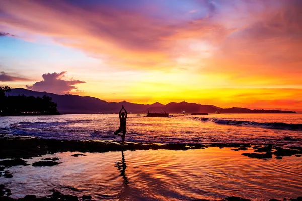 Donna caucasica che pratica yoga in riva al mare — Foto Stock