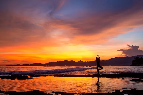 Mujer caucásica practicando yoga en la orilla del mar — Foto de Stock