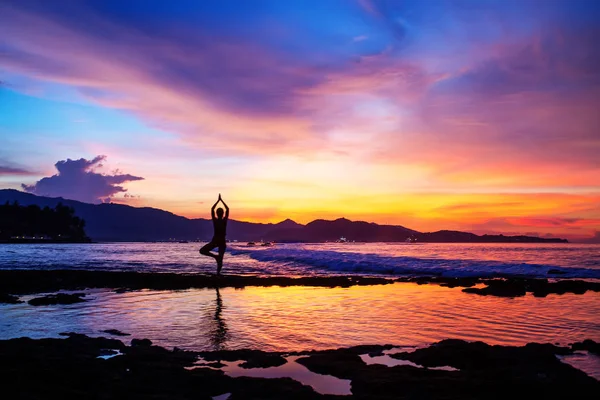 Mujer caucásica practicando yoga en la orilla del mar — Foto de Stock