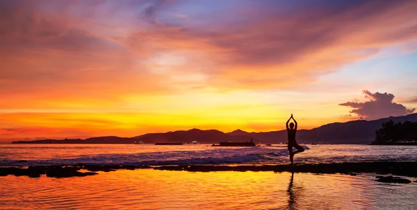 Mujer caucásica practicando yoga en la orilla del mar — Foto de Stock