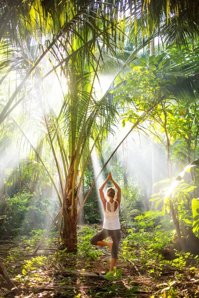 woman doing yoga outside in jungle