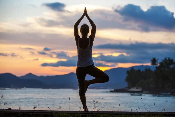 Mujer caucásica practicando yoga en la orilla del mar — Foto de Stock