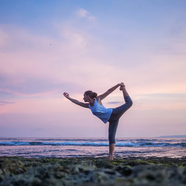 Mujer caucásica practicando yoga en la orilla del mar — Foto de Stock