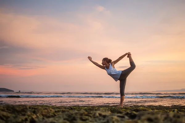 Mujer caucásica practicando yoga en la orilla del mar — Foto de Stock